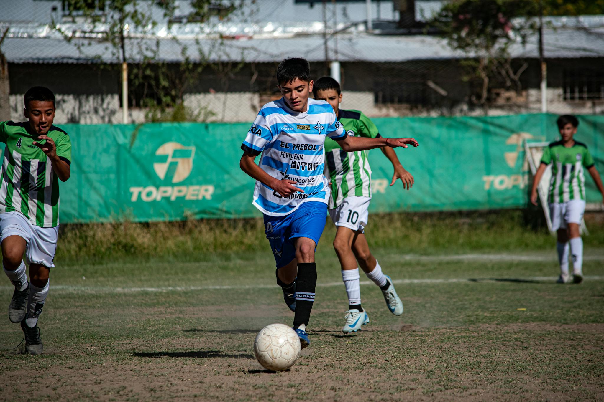 Young soccer players in a competitive match on a sunny day outdoors.